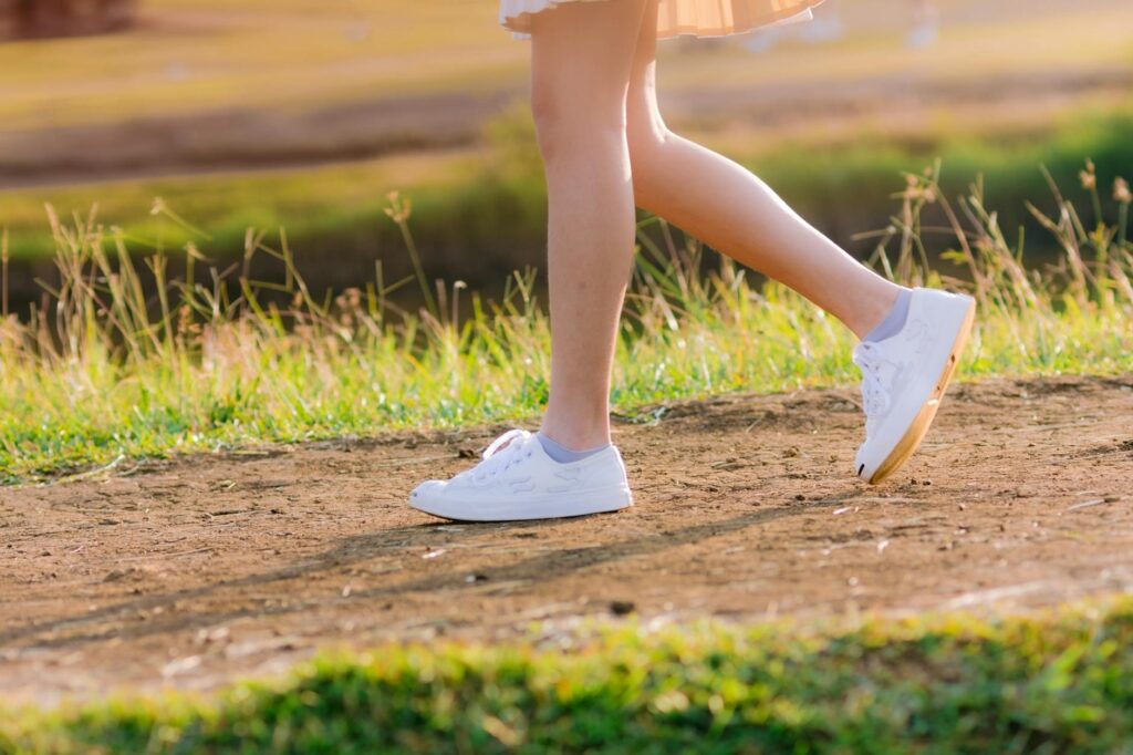 ウォーキングシューズを履いて歩く女性の足元